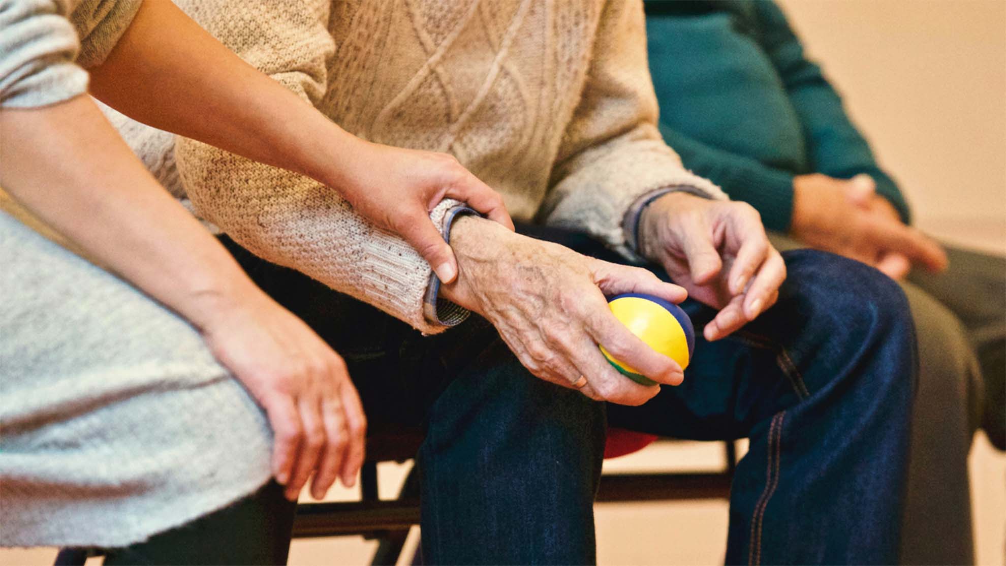 older adult holding a small ball